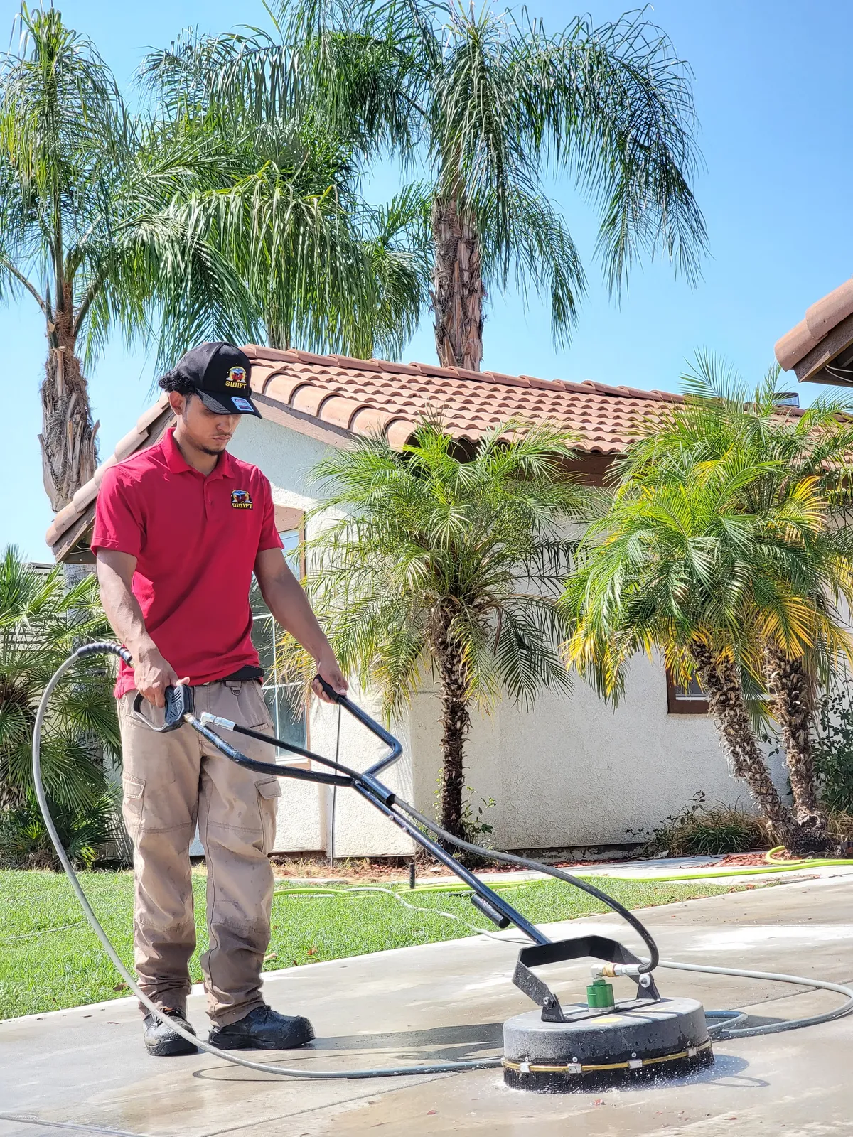 Driveway pressure washing in Bakersfield, CA — rotary surface cleaner deep-cleaning residential concrete driveway