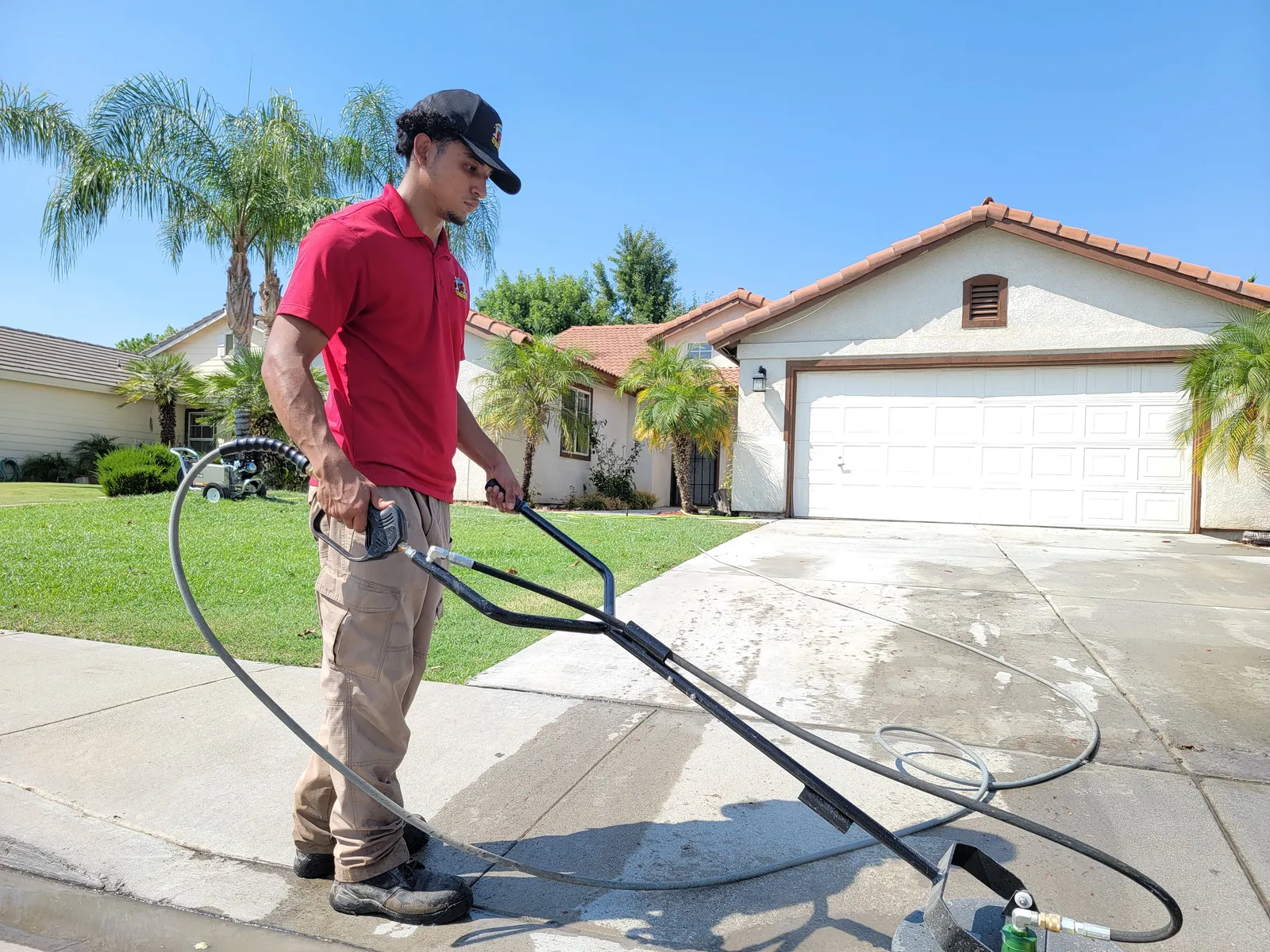 Driveway surface cleaning in Bakersfield, CA — pressure washing residential concrete to remove dirt, dust, and stains