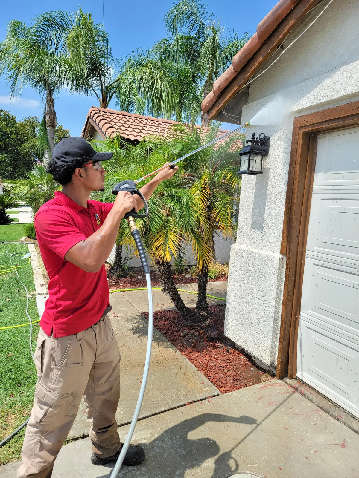 House soft washing in Bakersfield, CA — BrightSide Exterior Cleaning crew soft washing stucco siding and exterior walls on a residential home